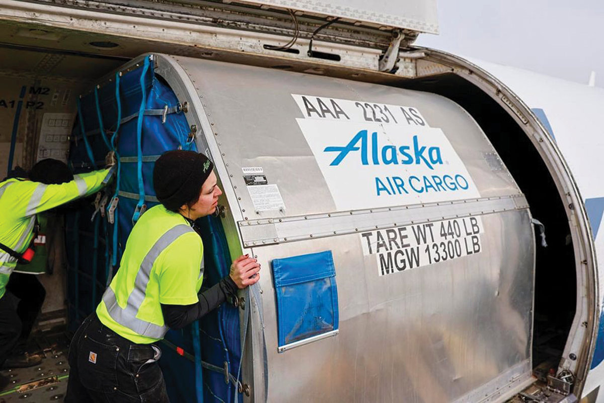 Auk Tosier and a coworker load recycling onto and Alaska Air Cargo plane