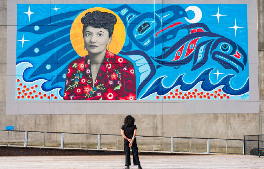 woman standing in front of building mural