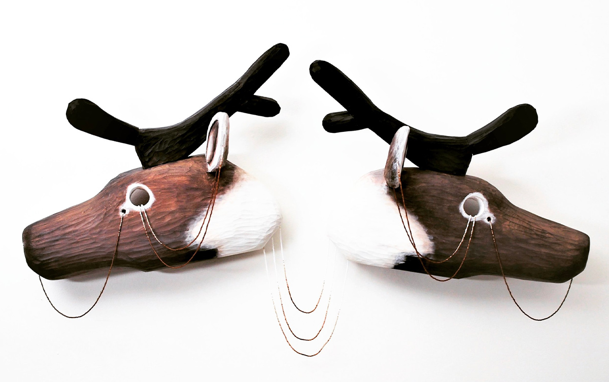 caribou head wooden sculptures with beads dangling